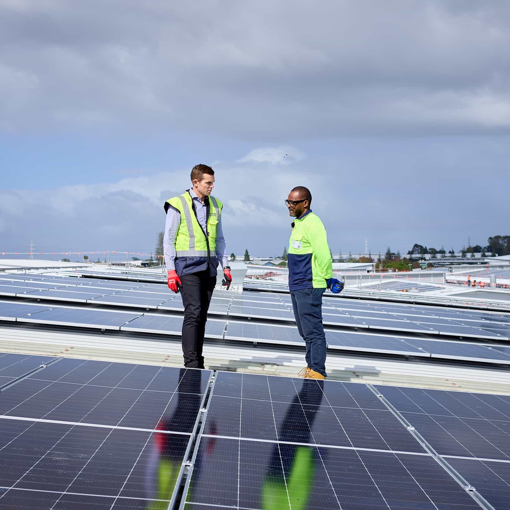 Jonti Rhodes and Paul Makumbe stand beside NZ’s largest rooftop solar array